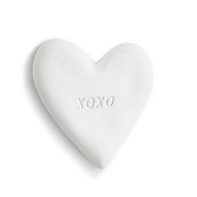 A white heart shaped diffuser stone with the imprint of XOXO on top.