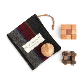 A set of three wood brain teaser puzzle games with a drawstring fabric bag for storage.