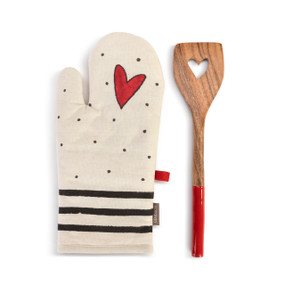 A cream oven mitt with a red heart and three black lines at the bottom, next to a wood spatula with a red handle and heart cutout.