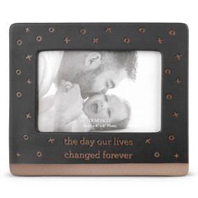 A dark brown ceramic frame with a brown textured base. The frame has X's and O's and says "the day our lives changed forever".