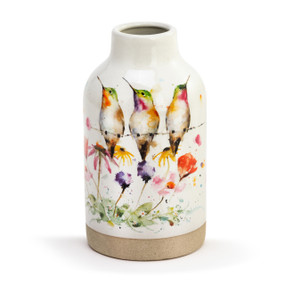 A cream stoneware vase with a watercolor image of three hummingbirds on a wire above wildflowers. The base of the vase is a textured tan.