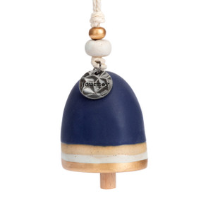 A mini navy blue bell with a metal tag at the top that says "journey". There are beads and a metal token at the top of the bell.