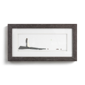 A dark wood framed wall art of a wedding couple standing together looking out to the horizon made with small stones.