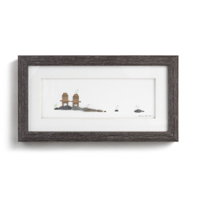 A dark wood framed wall art piece depicting two wood chairs on some stones with little light colored birds on the stones.