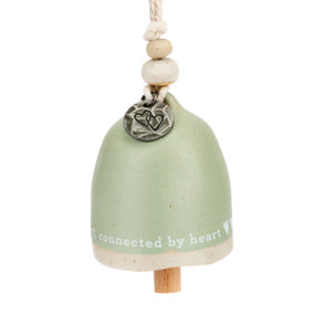 A mini light green bell that says "connected by heart". There are beads and a metal token at the top of the bell.