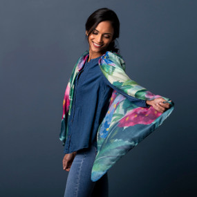 Profile view of a smiling woman wearing a dark blue shirt and a colorful red, blue and green scarf inspired by art created by ArtLifting artist Midori of a Hydrangea flower.