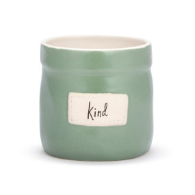 A green round stoneware planter with a cream interior and a cream patch on the front that says "Kind".