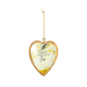 A hanging heart shaped wood ornament with a yellow and cream artwork inside inspired by ArtLifting artist Grace Goad. The ornament says "Wishes for a season full of Joy".