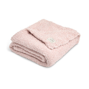 A soft light pink blanket with a fabric patch in the corner, displayed folded on a white background.