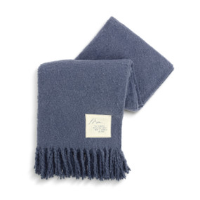 A blue fringed blanket with a fabric patch in the lower right corner that says "Mom, You Deserve Pace and Quiet With A Cuddle Or Two".