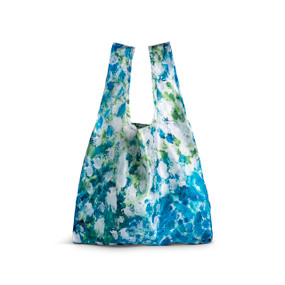 A fabric handled tote bag with artwork inspired by ArtLifting artist Mia Brown of a white and blue floral design.