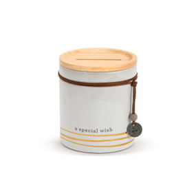 A white round ceramic container with gold lines at the bottom that says "a special wish". The container has a wood lid with an open slot and a leather cord around the jar with a metal token that says "wish".