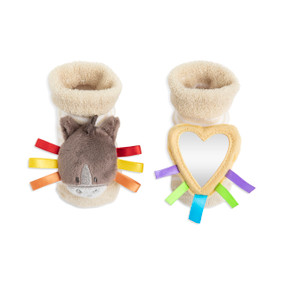 A pair of tan rattle baby socks. One has the face of a horse with colorful ribbons and the other has a heart shaped mirror with ribbons.