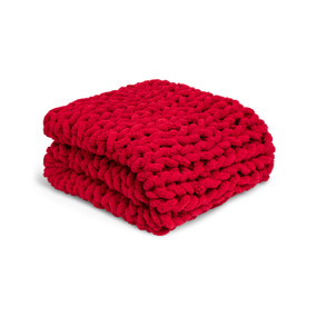 A red chunky knit blanket folded and displayed on a white background.