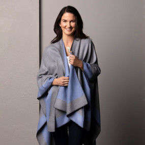 A smiling woman wearing a reversible blue and gray kimono with the gray side out.