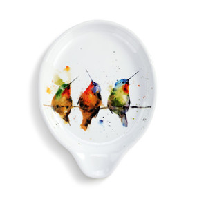 A white ceramic spoon rest with a watercolor image of three hummingbirds on a wire.