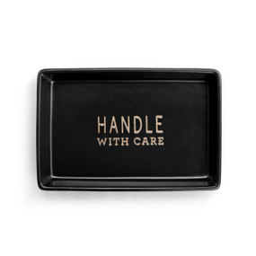 A black ceramic rectangular tray that says "Handle With Care" inside.