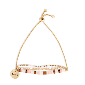 A gold chain adjustable bracelet with beads and tiles in brown pink and white. The bracelet also has a gold round charm that says Loved.
