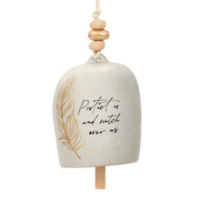 A cream bell with decorative beads and metal token. The bell has a brown feather on it and the saying "Protect us and watch over us".