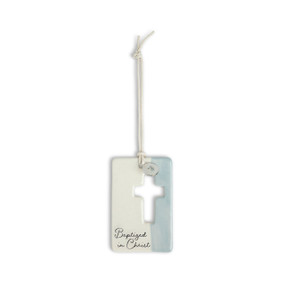 A blue and cream hanging token with a cross cutout and round silver charm with a heart attached to the hanger. The bottom of the token says "Baptized in Christ".