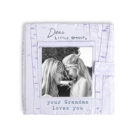 A light purple fabric photo book with a photo opening on the front and says "Dear Little Sprout, your Grandma loves you".