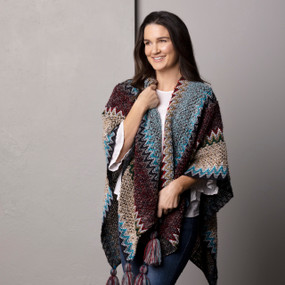 Front facing view of a smiling woman wearing a zigzag patterned kimono in shades of brown and turquoise.