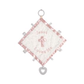 A soft white square blankie with a pink satin edge and a pink cross in the middle. The blankie says "Jesus Loves Me" and has ribbon tabs and a gray teether at the bottom.