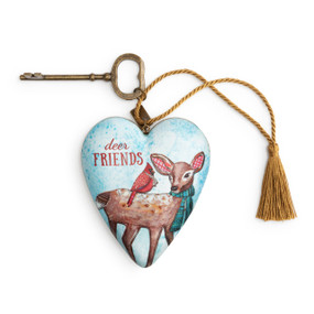 Heart shaped sculpture with a gold tassel and metal key attached. The heart has the image of a deer and cardinal on a blue background and says "deer Friends".