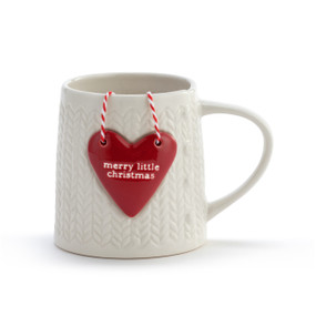 A white knit texture handled ceramic mug with a detachable red heart ornament that says "merry little christmas".