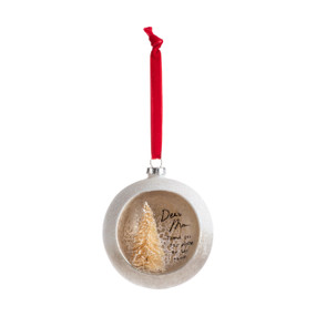 A silver ball ornament on a red ribbon with an opening at the front with a gold tree inside and a sentimental message about Mom.