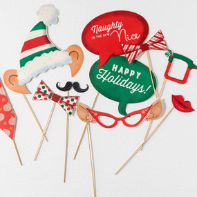 A close up cropped view of a set of Christmas themed paper photo props for taking selfies, including glasses, elf ears, speech bubbles and ties.
