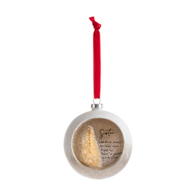 A silver ball ornament on a red ribbon with an opening at the front with a gold tree inside and a sentimental message for a sister.
