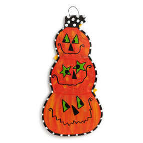 An orange pumpkin door hanger with three different jack o lantern faces stacked on each other.