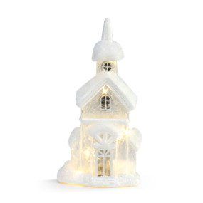 A white lit lantern shaped like a snow covered church.