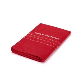 A red fabric table runner with white lines that says "merry Christmas" shown folded.
