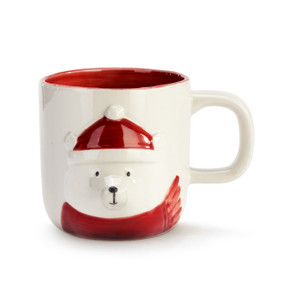 Cream ceramic handled mug with a raised image of a polar bear in a red scarf and Santa hat. The inside of the mug is red.