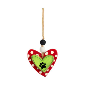 Heart shaped ornament in green and red with a black paw print in the center of the heart.