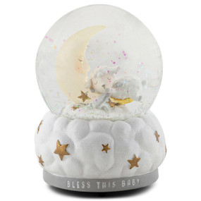 A musical snow globe with a sleeping lamb in a crescent moon inside. The base is white and looks like clouds with gold stars. The base says "Bless This Baby".