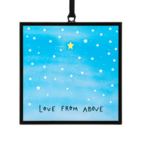 A small square shaped sun catcher that is blue with one yellow and lots of white stars and the saying "Love From Above".