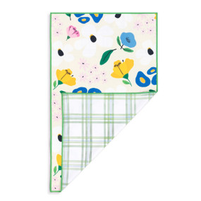 A rectangular double sided towel. One side is cream with colorful illustrated flowers and the other is white with green plaid pattern, displayed with the plaid corner turned back.