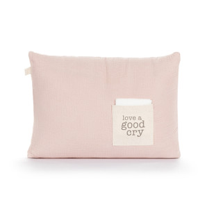 A light pink rectangular pillow with a cream fabric pocket on the front with the saying "love a good cry". The pocket has a white fabric folded in it, displayed with a product tag attached.