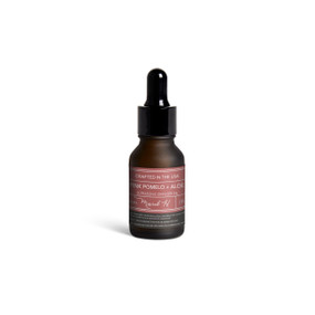A small dark bottle of Pink Pomelo + Aloe diffuser oil with a black dropper lid.