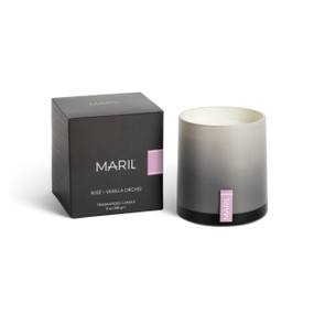 A Rosé + Vanilla Orchid poured candle in an ombre gray glass vessel sitting next to a dark gray packaging box.