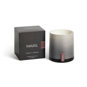 A Tobacco + Saffron poured candle in an ombre gray glass vessel sitting next to a dark gray packaging box.