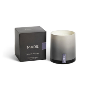 A Lavender + White Sage poured candle in an ombre gray glass vessel sitting next to a dark gray packaging box.