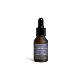 A small dark bottle of Lavender + White Sage diffuser oil with a black dropper lid.