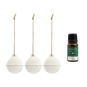 A set of three hanging white ceramic diffusers shaped like jingle bells that come with a small bottle of Douglas Fir fragrance oil.