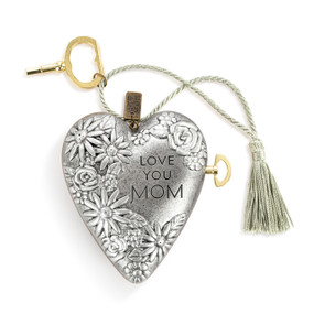 A silver heart shaped musical sculpture with a floral pattern that reads "Love You Mom". The heart has a silver tassel and gold key attached.