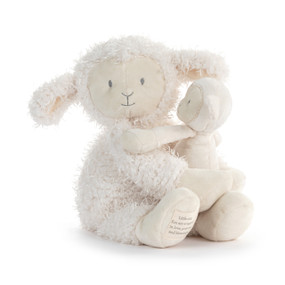 A white plush lamb sitting and holding a baby lamb in its lamp.