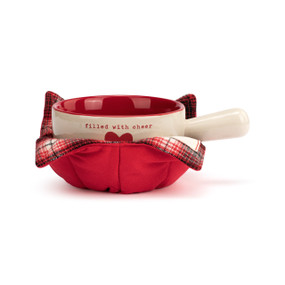 A cream handled soup bowl with a red interior inside a red fabric cozy. The bowl says "filled with cheer" with a red heart.